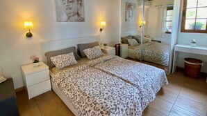 A bedroom with a large bed, bedside tables, a mirror, and a window. - Casa Albillo, Spanien (Puntagorda)