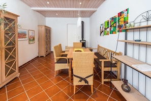Un comedor con una mesa y sillas de madera, una chimenea y obras de arte en la pared.
