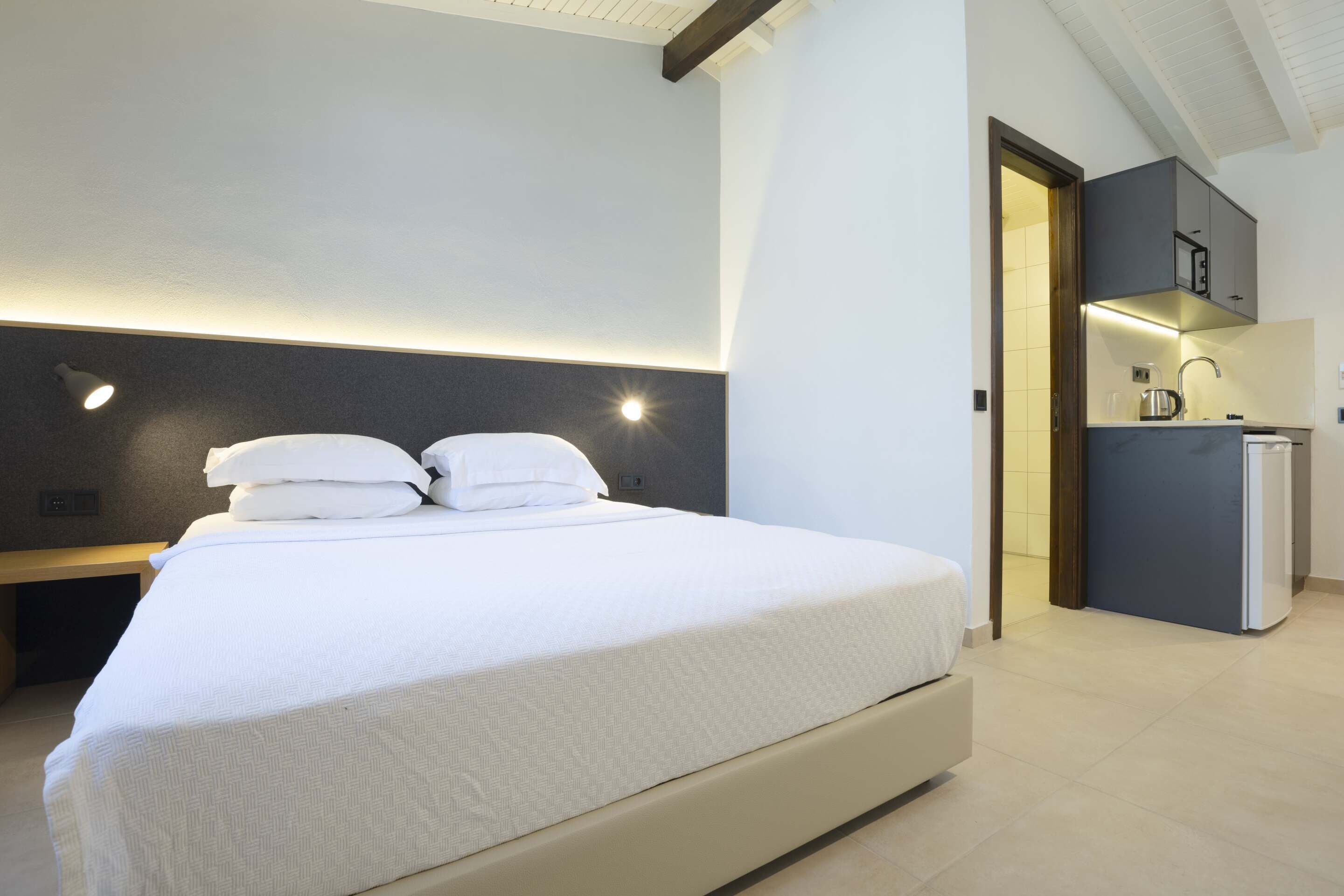 Een moderne slaapkamer met een groot bed, een nachtkastje en een inbouwkast.