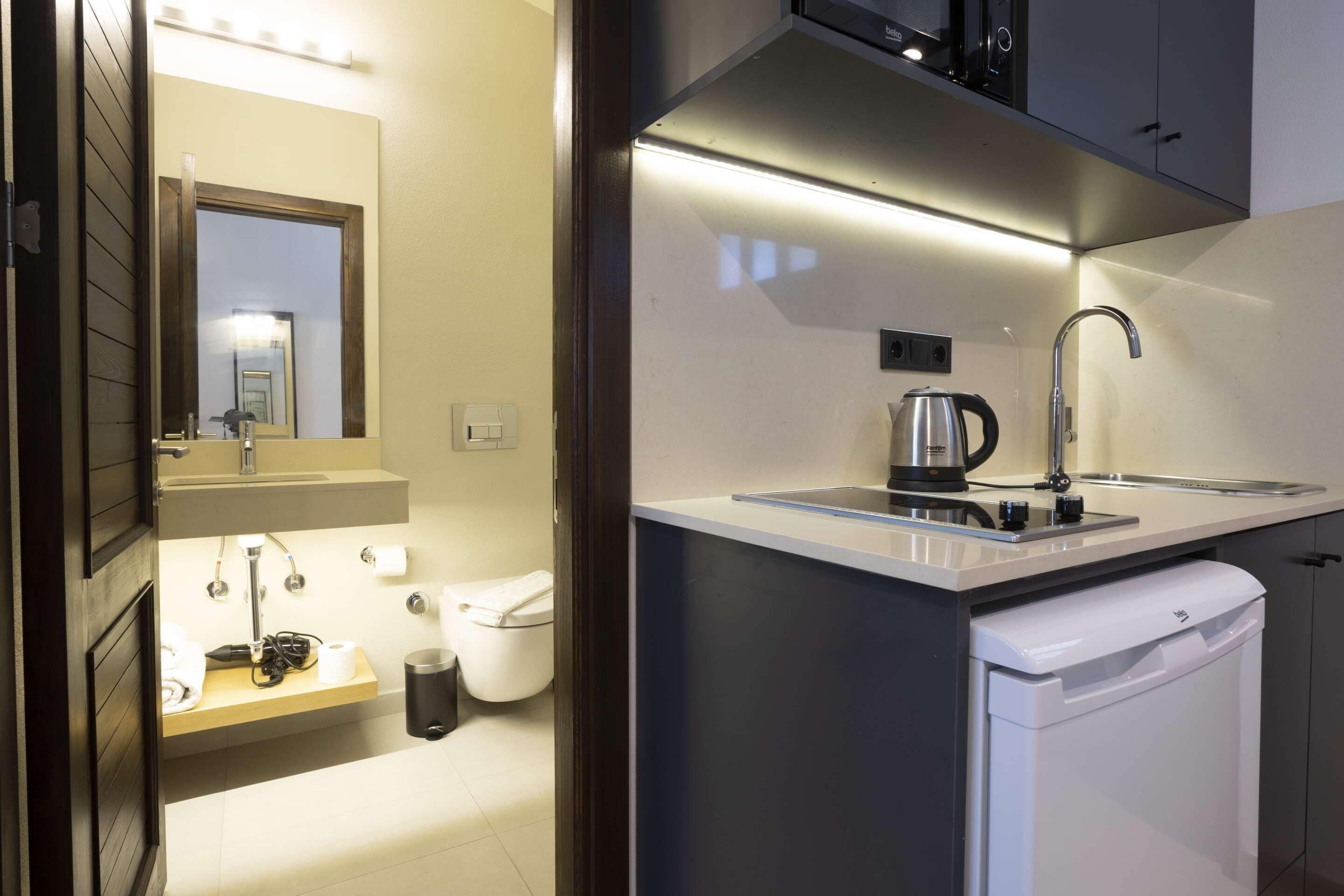 A modern bathroom with a toilet, sink, and mirror.