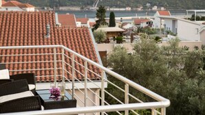 Una terraza con mobiliario exterior y vista al mar y edificios.