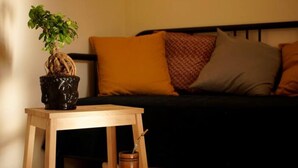Una pequeña mesa de madera con una planta en maceta y un candelabro.