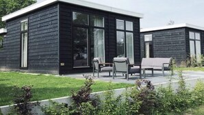 Un bâtiment moderne à deux étages, doté d’une façade sombre et de grandes fenêtres.