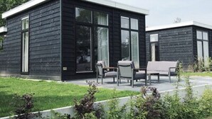 A modern two-story building with a dark exterior and large windows. - Holiday Home in Overijssel with Garden Terrace (Zuna)
