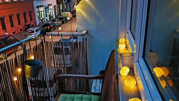 Un balcon avec un siège rembourré et une balustrade.