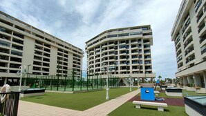 A residential building complex with multiple floors, outdoor recreational areas, and a well-maintained lawn. - NON STRESS First Level (Alboraya)