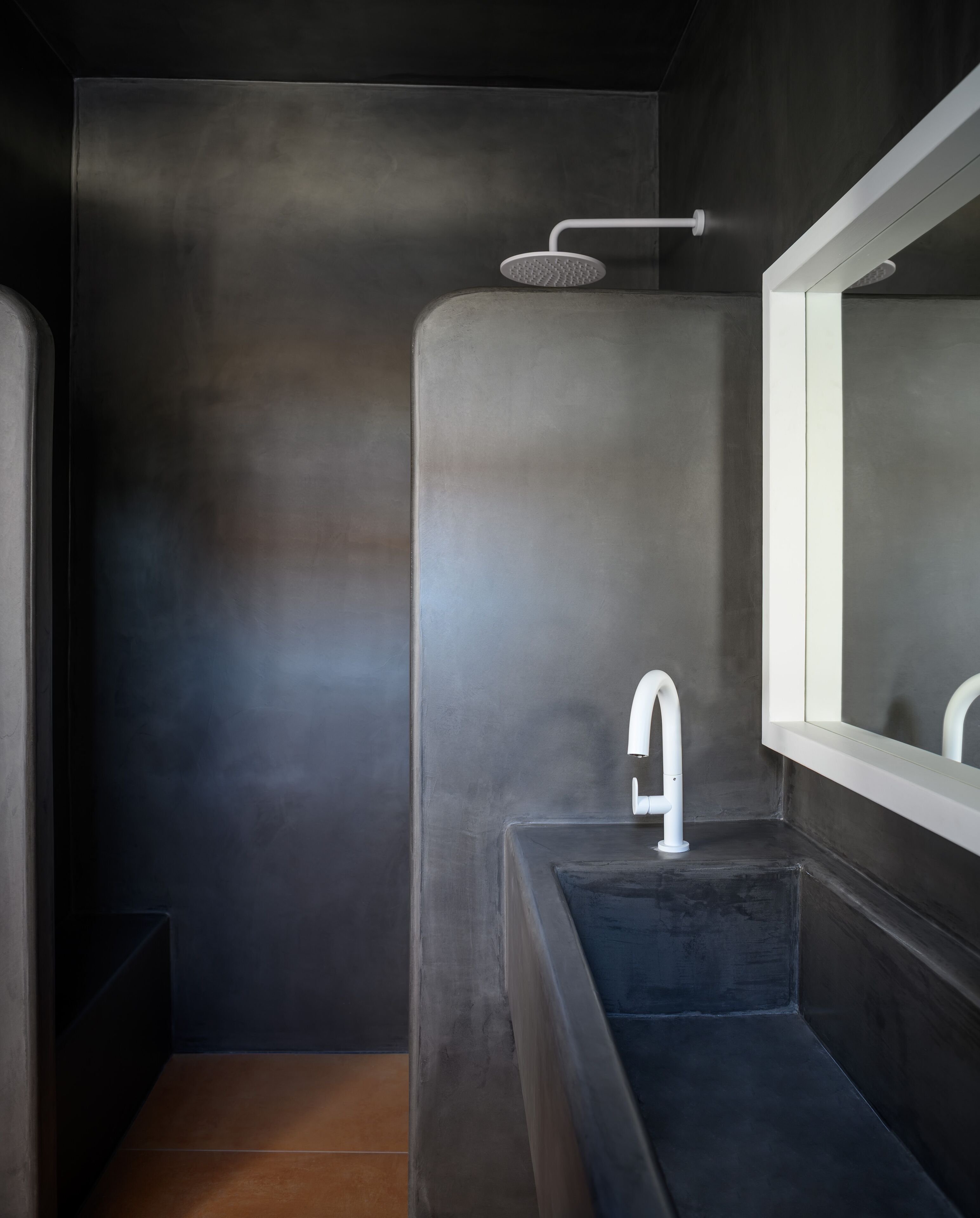 A modern bathroom with a large mirror, a bathtub, and a shower area.