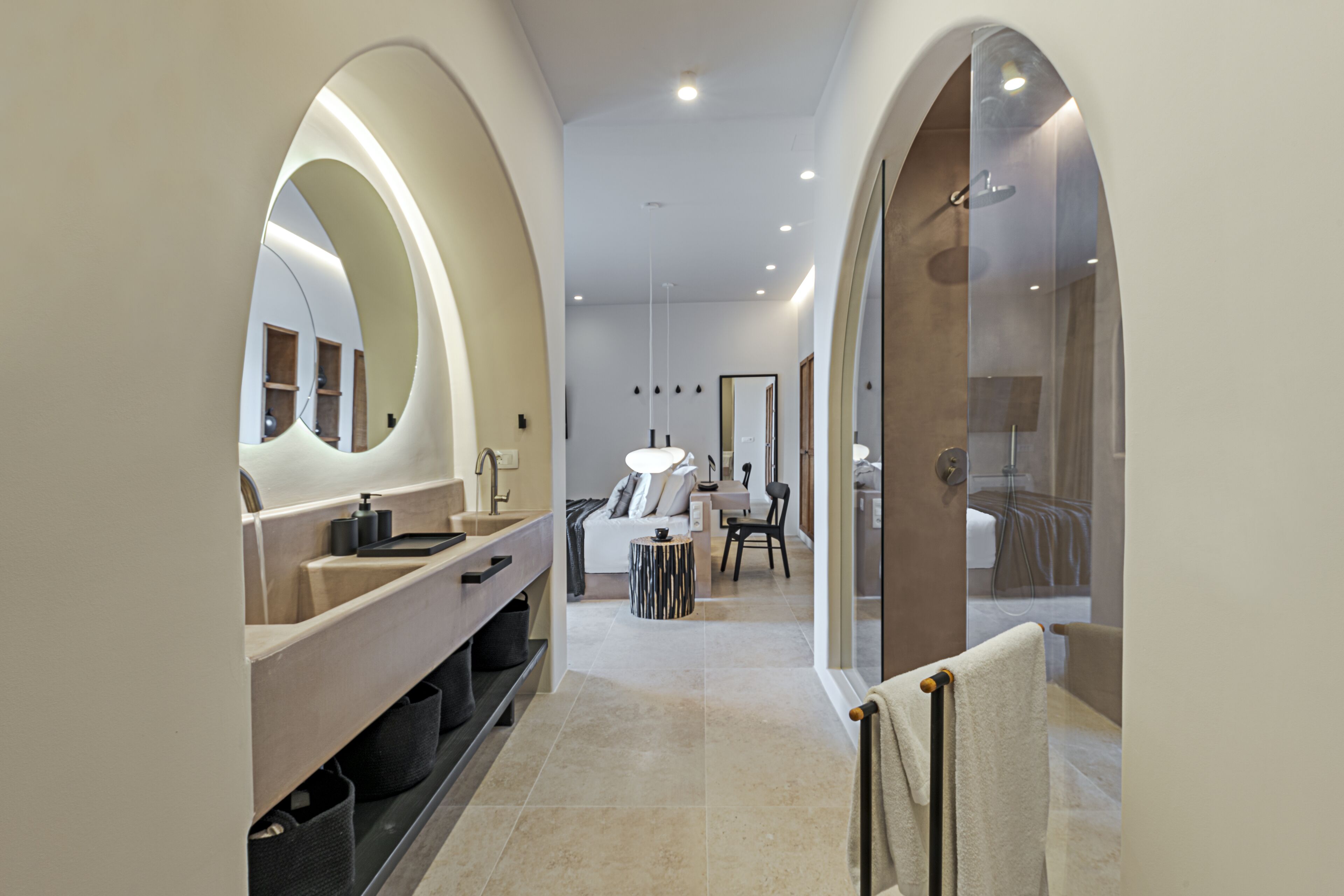A modern bathroom with a vanity, mirrors, and a shower area.
