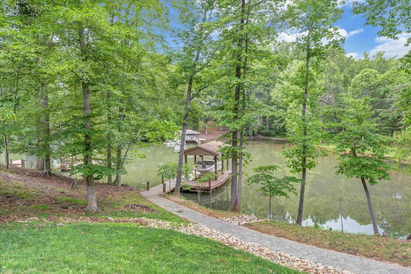 A dock with a gazebo, surrounded by trees and a calm lake.