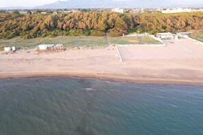An aerial view of a beach with a clear path, a fenced area, and a building in the background. - Villa close to the sea with terrace and free parking  (Licinella-Torre di Paestum)