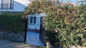 A residential building with a gated entrance, a tiled pathway, and a small garden area. - Villa close to the sea with terrace and free parking  (Licinella-Torre di Paestum)