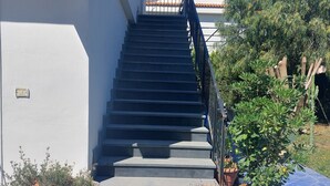 A staircase leading to a building with a tiled roof and potted plants at the base. - Villa close to the sea with terrace and free parking  (Licinella-Torre di Paestum)