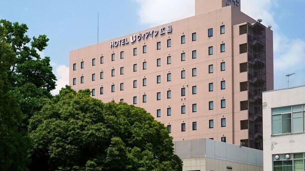 Un immeuble d’hôtel à plusieurs étages, doté d’une façade plane et de nombreuses fenêtres.
