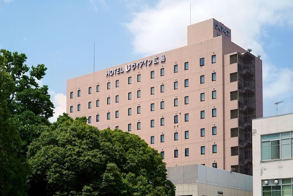 Un edificio de hotel de varios pisos con fachada plana y numerosas ventanas.