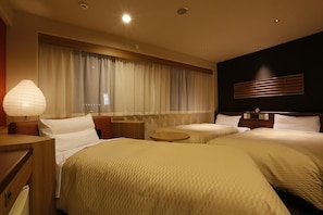 Habitación de hotel con dos camas, una mesita de noche, una lámpara, una ventana con cortinas y un reloj de pared.