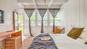 A bedroom with a bed, a wooden bench, a wicker basket, and a chair. - Ruschmeyers #17 - Dlx King (Montauk)