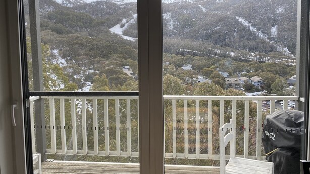 Ein Balkon mit Blick auf eine verschneite Berglandschaft.