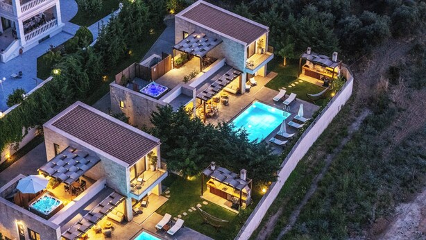 Ein modernes Mehrfamilienhaus mit Dachpool, Außenbereichen zum Sitzen und einem gepflegten Garten.