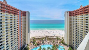 Un hotel de gran altura con vista a una playa y un área de piscina.