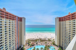 Un hotel de gran altura con vista a una playa y un área de piscina.