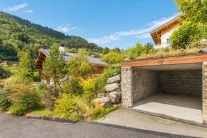 A residential area with a stone wall, a garage, and a wooden house with a sloped roof.