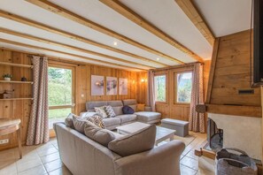 A wooden interior with a sectional sofa, a small table, and a fireplace. - Au Balcon de Verchaix - Chalet Exclusif Samoëns, Grand Massif Ski Area (Verchaix)