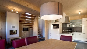 Una cocina moderna con gabinetes blancos, una campana extractora de acero inoxidable y un microondas integrado.