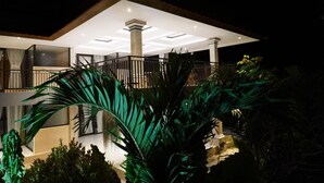 Ein modernes Gebäude mit überdachtem Außenbereich, Säulen und einem Balkon.