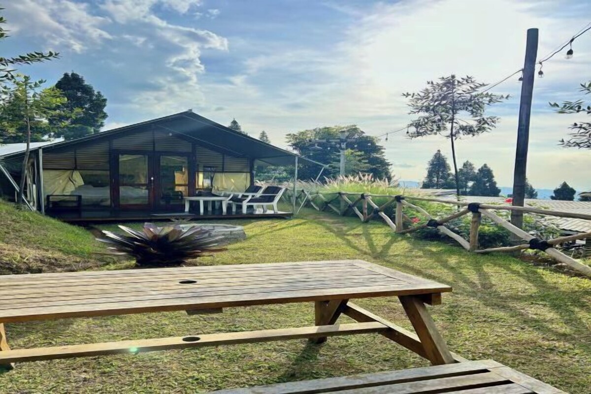 A modern house with a covered patio, a wooden table, and a view of the surrounding landscape.