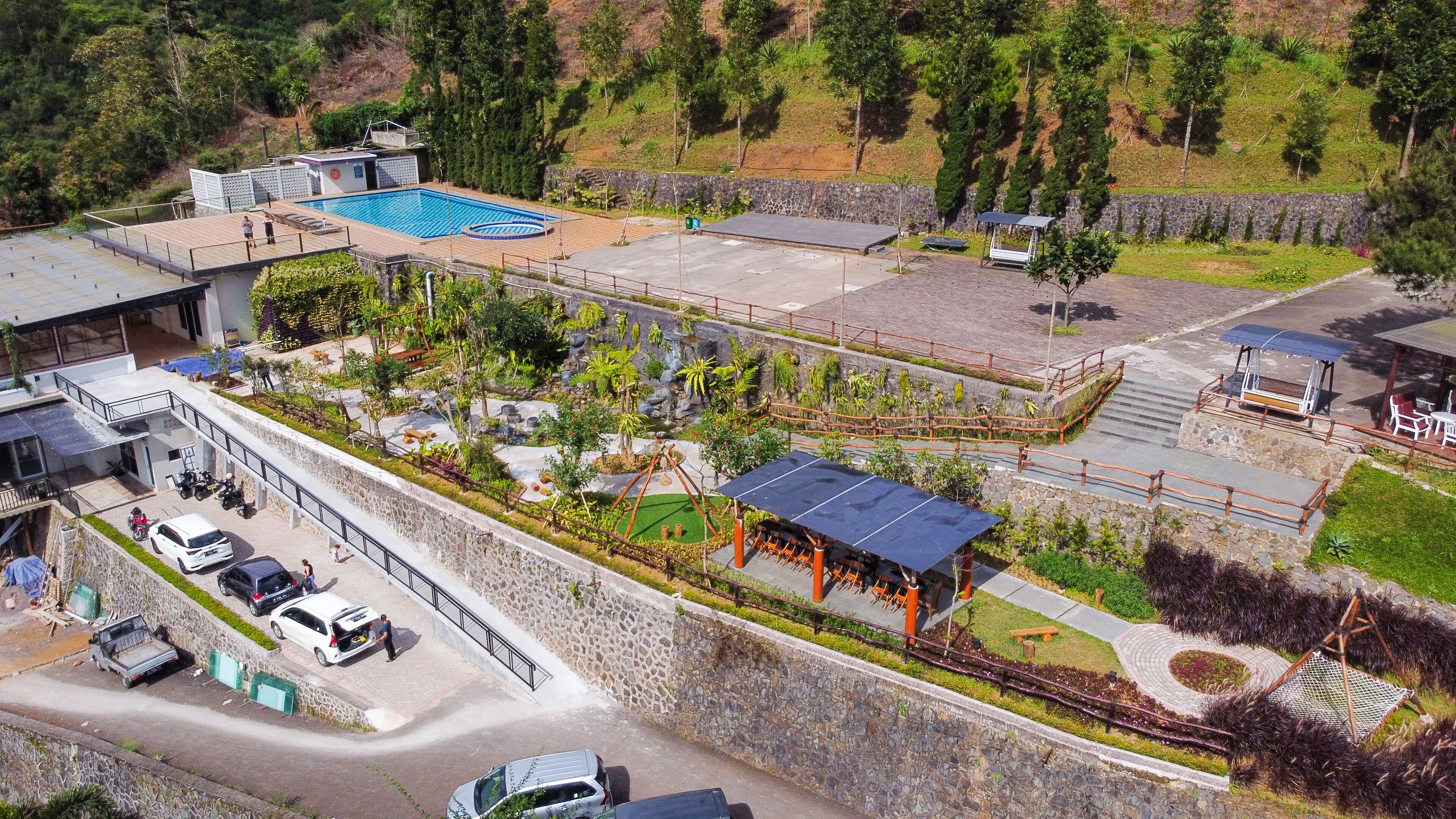 Un complexe hôtelier moderne doté d’une piscine, d’un espace extérieur aménagé et d’un parking.