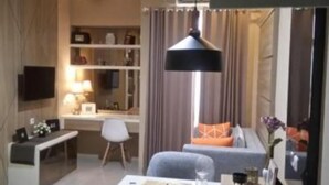 A modern living room with a TV, a dining table, and a sofa.