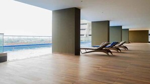 Un balcón amplio con suelo de madera y sillones de descanso.