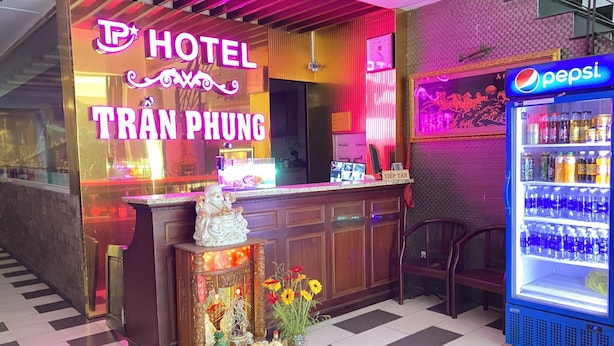 Een hotel met een neonbord, een Pepsi-koelkast en een decoratief altaar.