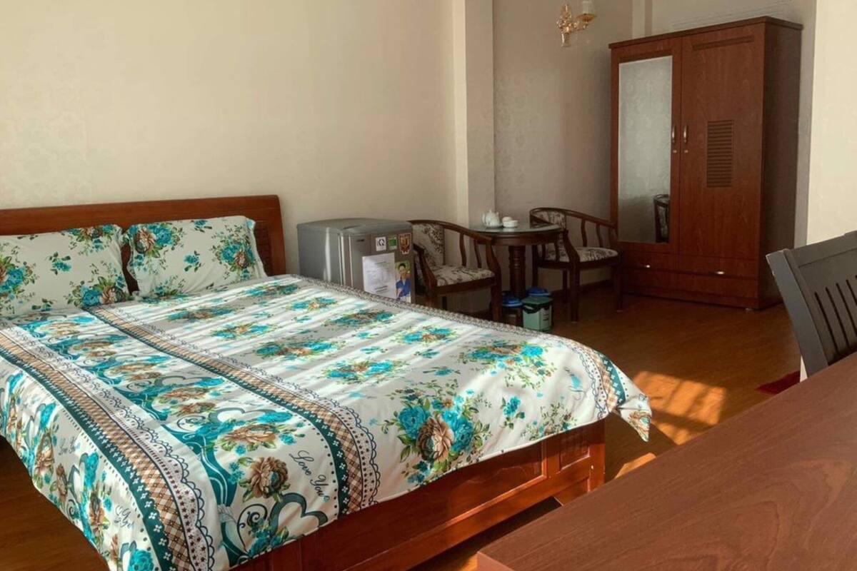 Una camera da letto con un letto, una scrivania, una sedia e un armadio.