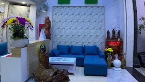 A modern interior with a curved ceiling displaying a nature scene, a blue sofa, and a decorative statue. - Hung Phat Hotel (Ho Chi Minh City)