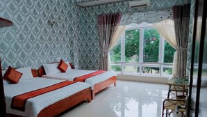 A hotel room with two beds, a window with curtains, a chair, and a patterned wallpaper. - An Binh Hotel (Ho Chi Minh City)