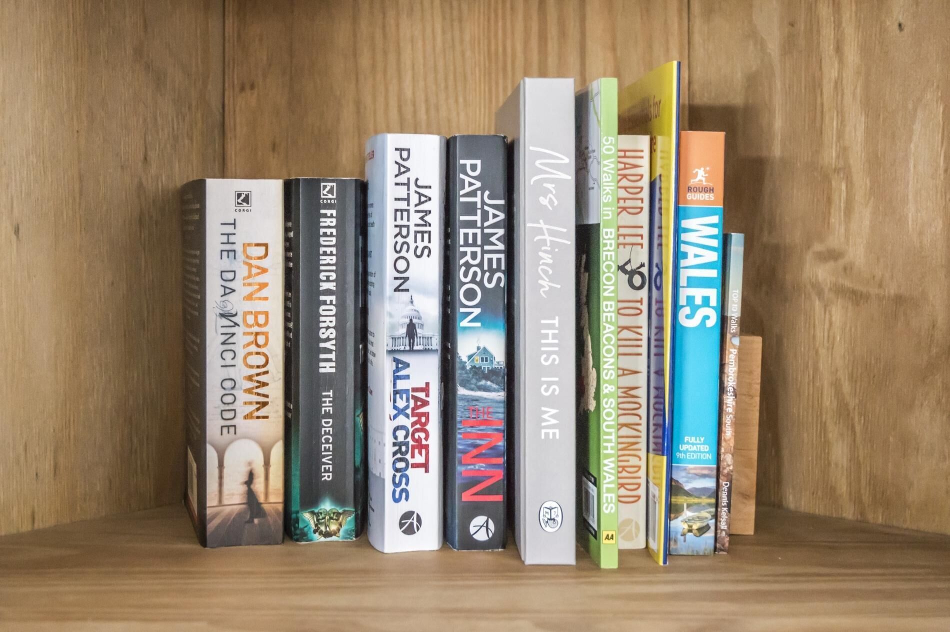 A bookshelf with various books, including titles like 'The Da Vinci Code' and 'A Tangled Web'.