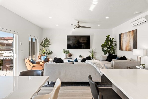 Relax in a spacious living area with a large flat-screen TV, comfortable seating, and a dining space.
