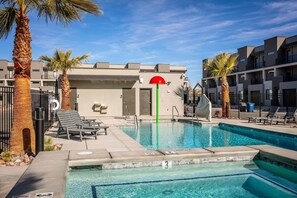 Relax by the pool surrounded by palm trees and lounge chairs.