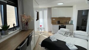 A modern hotel room with a bed, desk, and kitchenette. - Villa Laverna (Novalja)