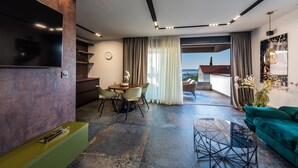 A modern living room with a dining area, a green sofa, and a view of the outside. - Villa Laverna (Novalja)