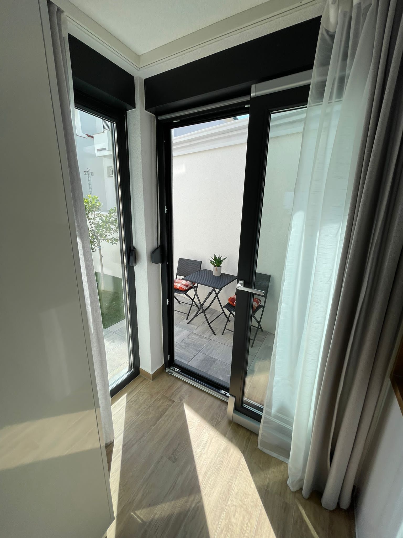 Quarto com porta de vidro deslizante que dá para um pátio externo.