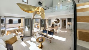 Amplia sala de estar con techo alto, comedor y cocina. Un ventanal grande ofrece vistas al exterior.