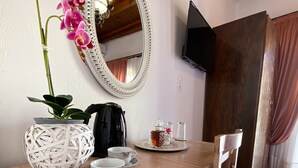 A wooden desk with a mirror, a potted orchid, a coffee maker, and a tea set. - Casa Dasyra (Chania)