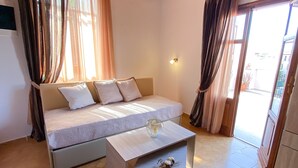 A modern living room with a sofa, a coffee table, and a view of the outside. - Casa Dasyra (Chania)