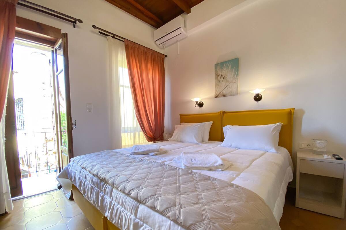 A hotel room with a bed, a nightstand, and a painting on the wall.