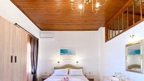 A bedroom with a wooden ceiling, a bed with white bedding, a nightstand, a dresser, and a mirror. - Casa Dasyra (Chania)