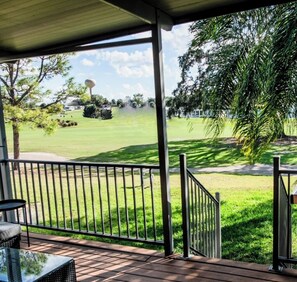 Relax in a serene outdoor space with a lawn view, featuring a table and chair for dining or unwinding.