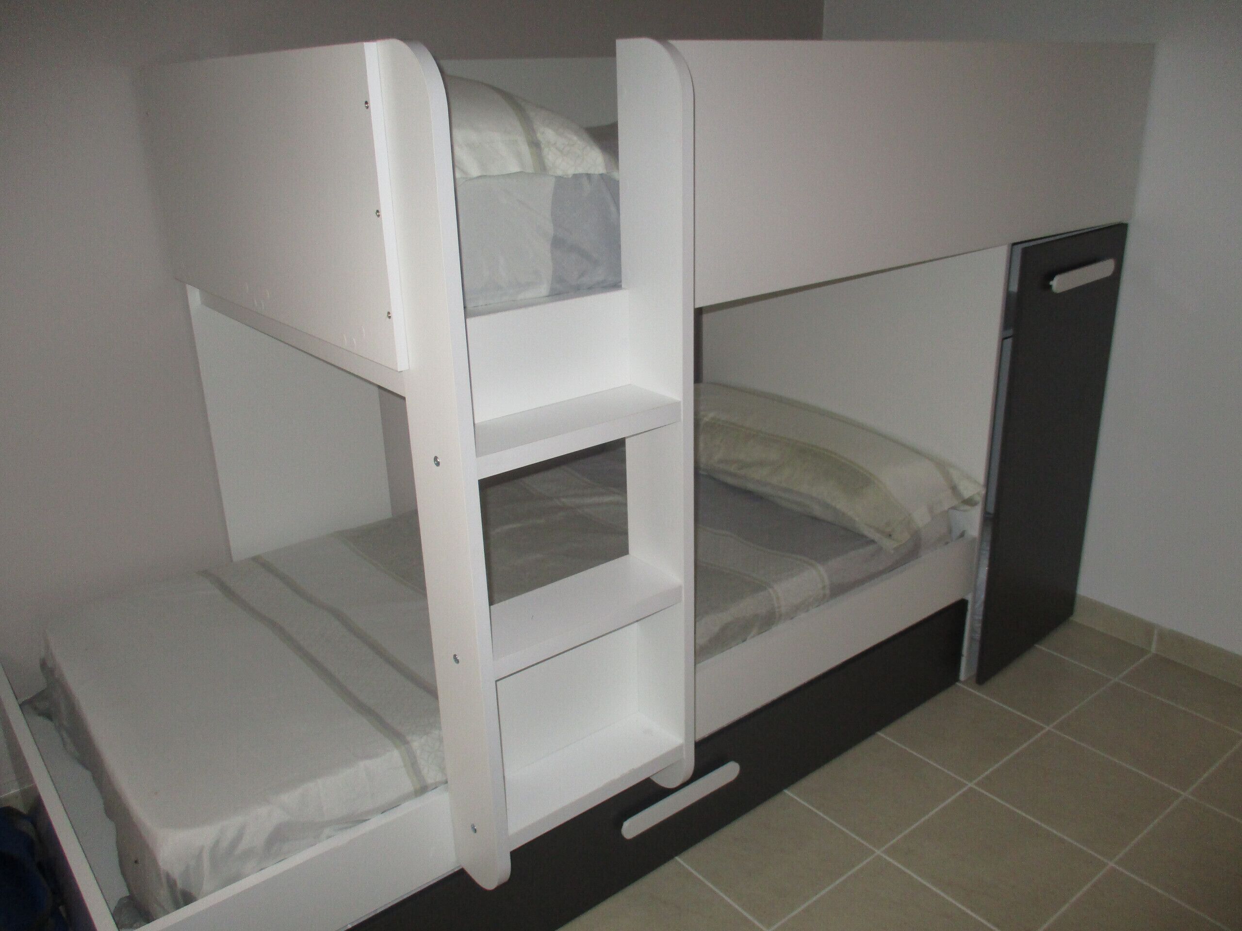 A bunk bed with a lower bunk and a pull-out desk.