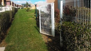 Un quartier résidentiel doté d’une pelouse bien entretenue, d’une entrée sécurisée et de maisons avec balcons.